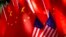 American flags are displayed together with Chinese flags on top of a trishaw in Beijing, Sept. 16, 2018. 