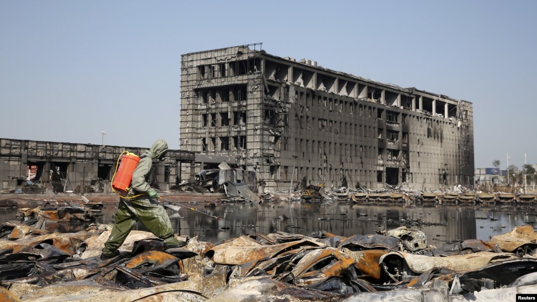 A People's Liberation Army soldier of its anti-chemical warfare corps in a protection suit sprays a liquid on debris at the site of last week's blasts in Tianjin, China, Aug. 21, 2015.