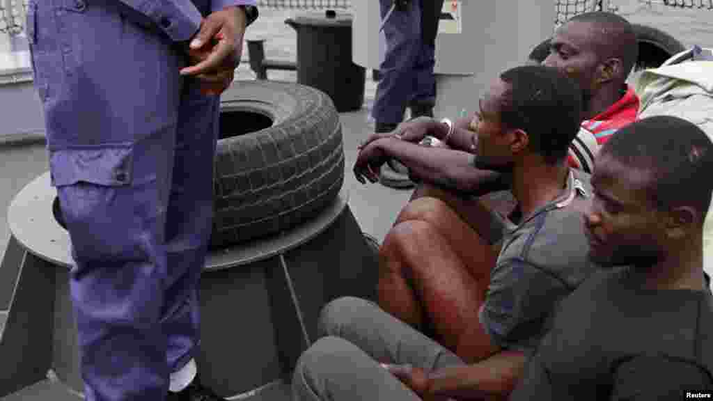 Naval police stand guard as suspected pirates are paraded aboard a naval ship after their arrest by the Nigerian Navy at a defence jetty in Lagos, August 20, 2013.