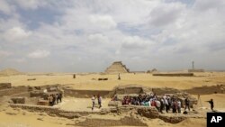 FILE - Archaeologists and journalists are seen at an excavation site in Egypt.