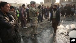 Seorang tentara AS mengambil foto di lokasi serangan bunuh diri di Kabul, Afghanistan (5/1).