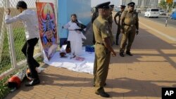 Sandya Ekneligoda, in black scarf, prepares ritualistic offerings for Hindu deity Kali seeking her blessings to find her missing husband, journalist Prageeth Ekneligoda, outside the office of the President in Colombo, Sri Lanka, Jan. 24, 2019.