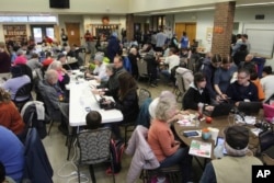 People gather to charge their electronic devices, keep warm and eat snacks at a senior center in Issaquah, Washington, Nov. 22, 2024, after high winds from a storm knocked out power.