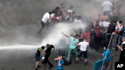 Lebanese activists are sprayed by riot police using water cannons during a protest against the ongoing trash crisis, in downtown Beirut, Lebanon, Aug. 23, 2015. 