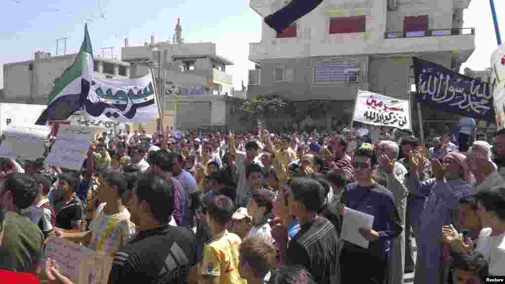 Demonstran berdoa di tengah-tengah aksi protes anti-pemerintah di Sermeen, dekat Idlib, Suriah, Jumat (17/8).