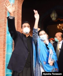 Aseefa Bhutto-Zardari makes a victory sign for the crowd. Standing next to her is Pakistan's former Prime Minister Yousaf Raza Gilani.