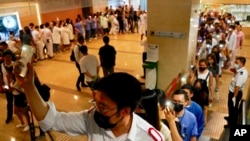 Medical workers show their palm with five fingers, signifying the five demands of protesters and chanted slogans as they stood in the foyer of the hospital at the Prince of Wales Hospital in Hong Kong, ept. 16, 2019.