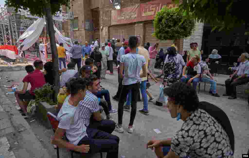 Some young men say &quot;brokers&quot; pay them to sit outside polls, presumably to create the appearance of greater youth participation in the election, in Cairo, Aug. 11, 2020. 