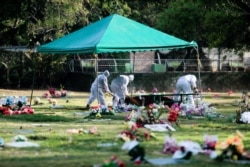 Los sepultureros en Nicaragua usan trajes protectores para enterrar a las personas sospechosas de haber muerto de COVID-19.