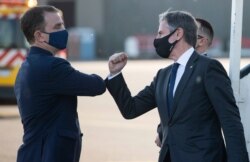 United States Secretary of State Antony Blinken, right, greets the US Charge d'Affaires to Belgium Nicholas Berliner as he disembarks from his airplane upon arrival at Brussels Airport in Brussels, June 12, 2021.