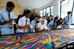 In this handout photograph taken on Sept. 13, 2024 and released by Vatican Media, Pope Francis (C) takes part in an interreligious meeting with young people at the Catholic Junior College in Singapore.