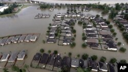 Homes are surrounded by floodwaters from Tropical Storm Harvey, Aug. 29, 2017, in Spring, Texas. Congress is considering renewing the National Flood Insurance Program.