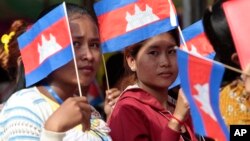 Garment workers welcome Prime Minister Hun Sen outside of Phnom Penh, Cambodia, Wednesday, Aug. 30, 2017. Hun Sen is on a country-wide trip to visit the nation's factory workers to hear their hopes and concerns in person. (AP Photo/Heng Sinith)