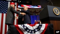 President Donald Trump gets ready to embrace U.S. Senate candidate Luther Strange during a campaign rally, in Huntsville, Alabama, Sept. 22, 2017.