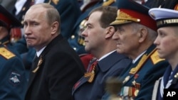 Russian President Putin and Prime Minister Medvedev, center, watch Victory Day Parade, Moscow, May 9, 2012.