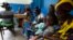 Women holding children wait for a medical examination at the health centre in Gbangbegouine village, western Ivory Coast, July 4, 2013. 