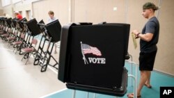 Voters cast their ballots in a polling station at Quest Community Church, Aug. 7, 2018, in Westerville, Ohio.