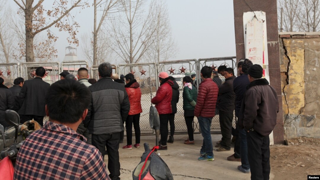 Warga setempat berdiri di luar komplek tambang yang roboh di provinsi Shandong, China timur Jumat (25/12).