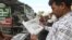FILE - People read newspapers carrying headlines about India Pakistan tensions, in Karachi, Pakistan, Feb. 28, 2019.