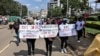 FILE - Protesters carry banners and chant slogans as they march through Eldoret, western Kenya, , to demonstrate against the murder of women in Kenya, on Sept. 13, 2024.