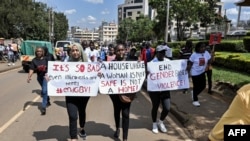 FILE - Protesters carry banners and chant slogans as they march through Eldoret, western Kenya, , to demonstrate against the murder of women in Kenya, on Sept. 13, 2024.