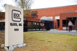 FILE - A security guard stands outside the Glock Inc. headquarters in Smyrna, Ga., Oct. 8, 2014. Glock is one of the gunmakers Mexico sued on Aug. 4, 2021, in U.S. federal court.