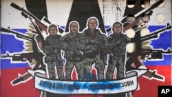 FILE: A mural depicting mercenaries of Russia's Wagner Group that reads: "Wagner Group - Russian knights" vandalized with paint on a wall in Belgrade, Serbia, on Jan. 13, 2023.