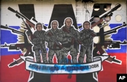 Sebuah mural yang menggambarkan tentara bayaran dari Grup Wagner Rusia yang berbunyi: "Grup Wagner - Ksatria Rusia" dirusak dengan cat di dinding di Beograd, Serbia, pada 13 Januari 2023. (Foto: AP)