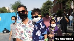 Warga Iran mengenakan masker wajah di jalan di tengah pandemi virus corona, Tehran, Iran, 28 Juni 2020.