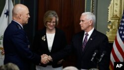 El vicepresidente de EE.UU., Mike Pence (der.), felicita al general de la Fuerza Aérea John Raymond, luego de que éste prestó juramento como Jefe de Operaciones Espaciales. En medio de ambos Molly, la esposa del general Raymond. Enero 14, 2020. AP/Steve Helber.