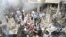A crowd gathers in front of a building and car damaged after a bomb explosion in the Mezzeh 86 area in Damascus, in this handout photograph released by Syria's national news agency SANA, November 5, 2012. 