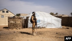 FILE: A Burkina Faso soldier patrols at a camp sheltering Internally Displaced People (IDP) from northern Burkina Faso in Dori. - taken Feb. 3, 2020