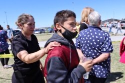 Adela Rodriguez, left, walks with her son, Yandel Rodriguez, 12, at the high school where people were evacuated after a shooting at the nearby Rigby Middle School, May 6, 2021, in Rigby, Idaho.
