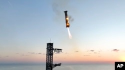 This image provided by SpaceX shows SpaceX's mega rocket booster returning to the launch pad to be captured during a test flight Sunday, Oct. 13, 2024, in Boca Chica, Texas. (SpaceX via AP)