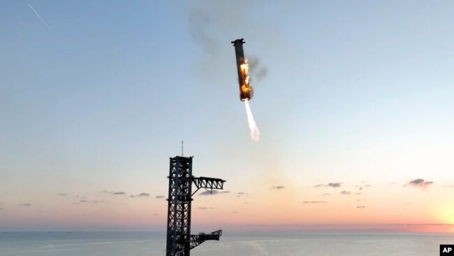 This image provided by SpaceX shows SpaceX's mega rocket booster returning to the launch pad to be captured during a test flight Sunday, Oct. 13, 2024, in Boca Chica, Texas. (SpaceX via AP)