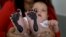 In this May 2, 2019 file photo, Arelys Pulido holds her two-month-old daughter Zuleidys after she had her feet prints taken for her birth certificate at the Erazmo Meoz hospital in Cucuta, on Colombia's border with Venezuela.
