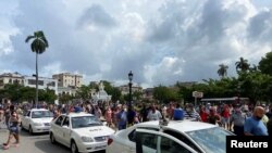 El pueblo se acerca a los autos policiales durante las manifestaciones ocurridas en Cuba el 11 de julio de 2021. En la imagen parte de los sucesos frente al Capitolio de La Habana, la capital.