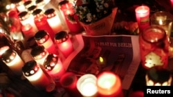 Candles burn at a Christmas market at Breitscheidplatz in Berlin, Germany, Dec. 20, 2016, to commemorate the 12 victims of a truck that ploughed into the crowded market. 