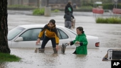 Aidan Perez, left, 12, and Christopher Dow, 11, use a shopping cart to get around after a severe storm flooded a shopping center parking lot in Healdsburg, Calif., Dec. 11, 2014.