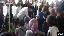 Presiden Joko Widodo berbincang dengan para korban gempa di dekat bandara Palu, Sulawesi Tengah, Rabu 3/10. (Y. Litha/VOA)