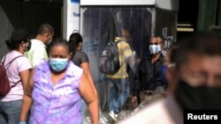 La gente camina por las calles de Guayaquil, Ecuador, después que se permitiera que algunas empresas reabrieran el miércoles después de una caída en las muertes diarias debido al brote de la enfermedad por coronavirus, el 20 de mayo de 2020.