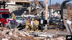 Pihak berwenang memeriksa kerusakan pasca tornado melanda kota Mayfield, Kentucky, Sabtu (11/12). 