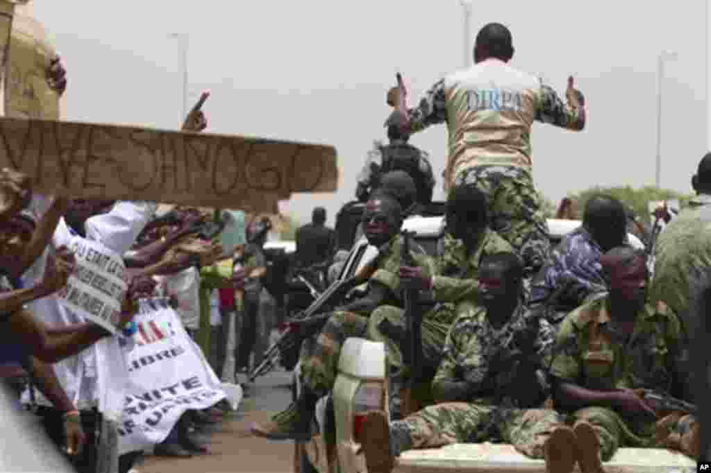 People supporting the recent military coup cheer as the convoy carrying coup leader Capt. Amadou Haya Sanogo leaves the airport in Bamako, Mali Thursday, March 29, 2012.