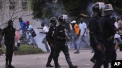 Demonstraters disperse because of tear gas thrown into the crowd by riot police during clashes in Abidjan on November 19, 2010.