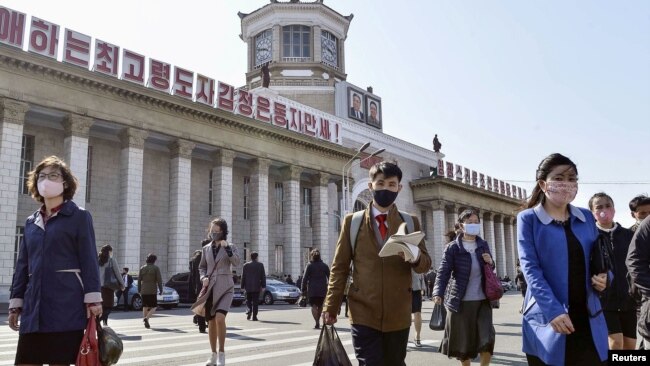 북한 평양역에서 행인들이 신종 코로나바이러스 감염을 막기 위해 마스크를 쓰고 있다.