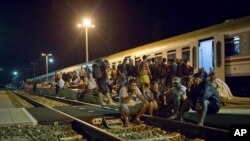 Migrantes descansan cerca de una estación de trenes en Beli Manastir, cerca de la frontera húngara, en el noreste de Croacia, el viernes, 18 de septiembre de 2015.