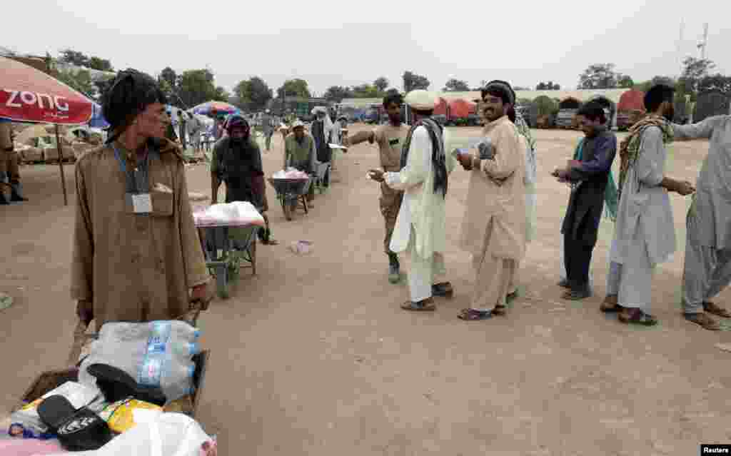 بنوں کے ایک مرکز سے نقل مکانی کرنے والے لوگ راشن لے کر جا رہے ہیں۔