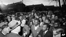 Wilson Baker, left foreground, public safety director, warns of the dangers of night demonstrations at the start of a march in Selma, Alabama, Feb. 23, 1965.