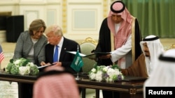 Saudi Arabia's King Salman bin Abdulaziz Al Saud (right) and U.S. President Donald Trump sign a joint security agreement at the Royal Court in Riyadh, Saudi Arabia, May 20, 2017.