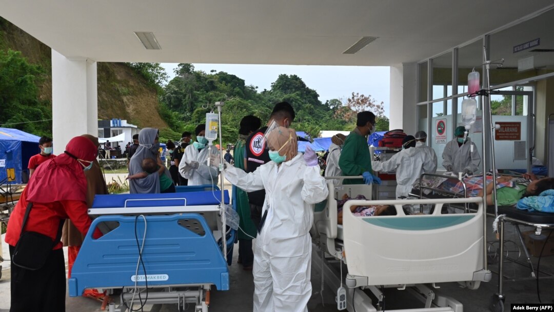 Korban luka-luka akibat gempa 6,2 magnitudo yang mengguncang pada 15 Januari lalu sedang dirawat di luar sebuah rumah sakit karena takut gempa susulan, di Mamuju, Sulawesi Barat, Minggu, 17 Januari 2021. (Foto: Adek Berry/AFP)
